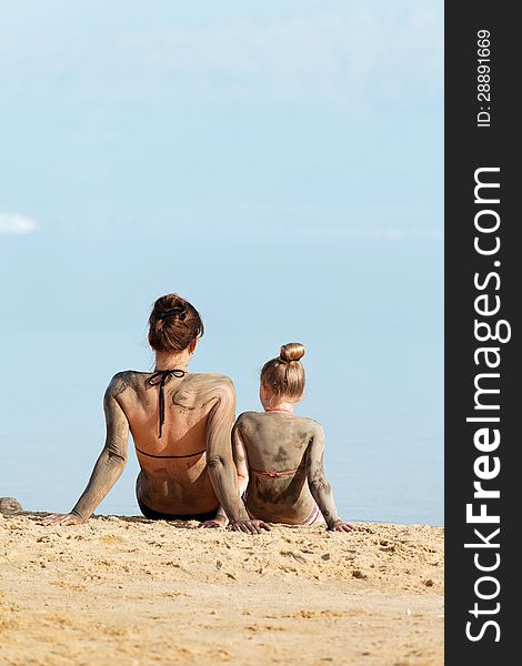 Mother and daughter resting in a bikini by the sea