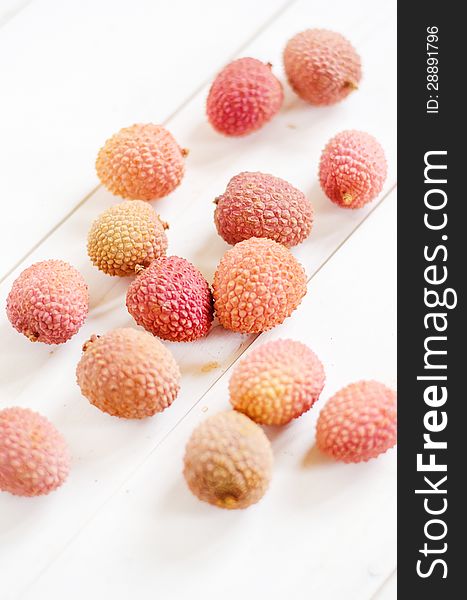 Fresh litchis on a white wooden table