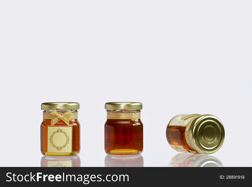 Honey in the bottle on white background