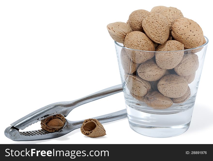 Cup with almonds and nutcracker on white background