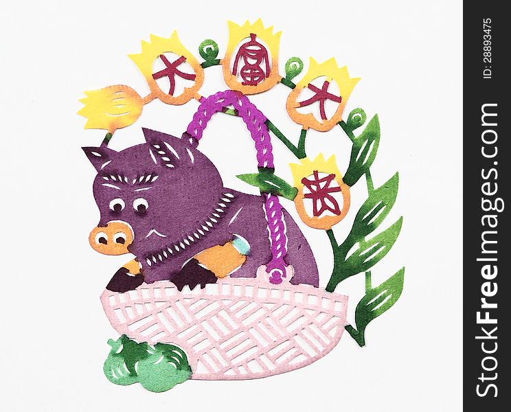 Paper-cut of a pig in a basket together with four Chinese characters â€œDa Fu Da Guiâ€ which mean â€œriches and honourâ€.