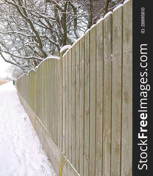 A fence covered with snow. A fence covered with snow.