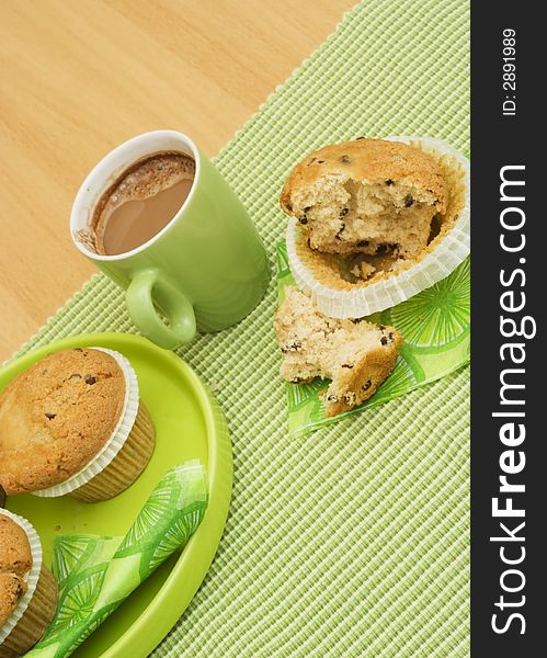 Muffin and cappuccino on green plates