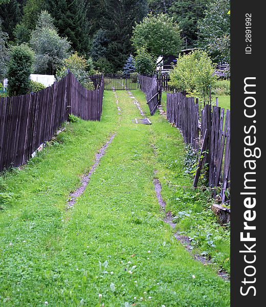 A small grassy mountain path between two fences. A small grassy mountain path between two fences