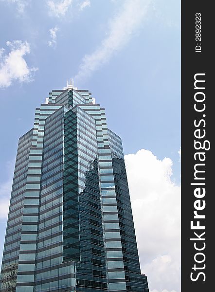 A modern blue office tower rising into the clouds. A modern blue office tower rising into the clouds