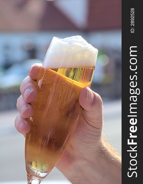 Hand holding a refreshing german lager