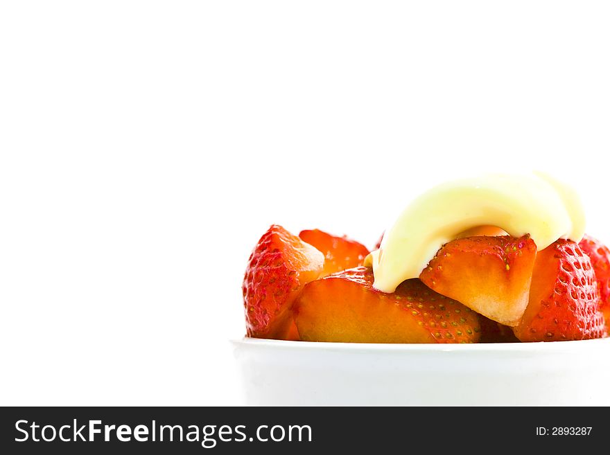 Bowl of cut strawberries in white bowl with cream isolated over white. Bowl of cut strawberries in white bowl with cream isolated over white