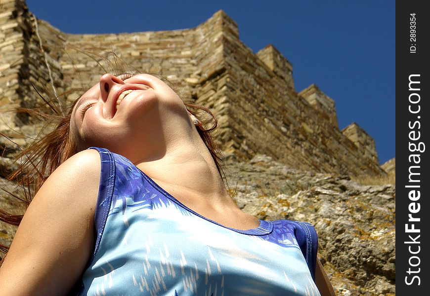 Laughing girl near ancient castle