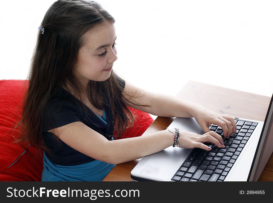 Young girl sitting down and working on a laptop. Young girl sitting down and working on a laptop