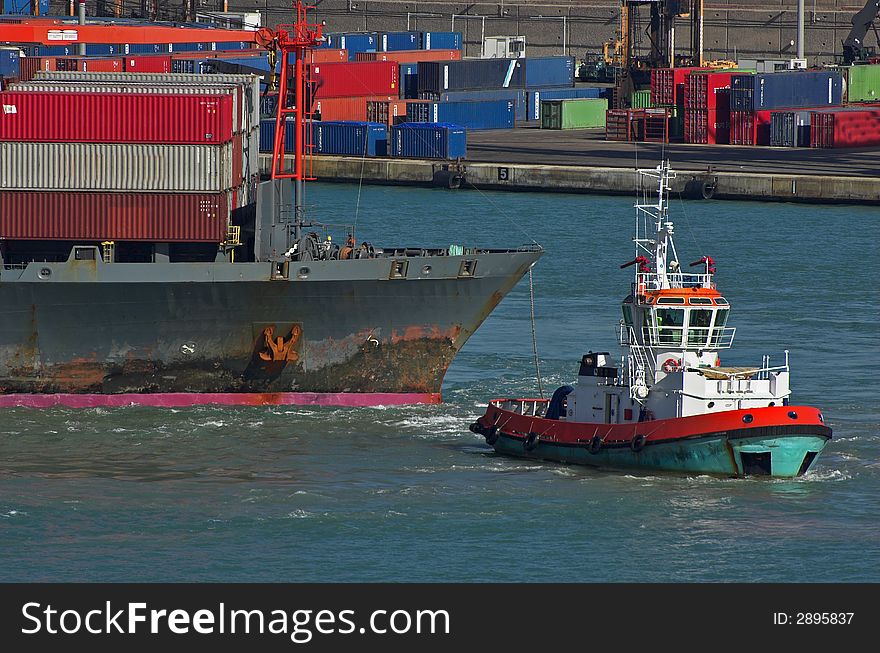 Container ship and tag boat in the harbour