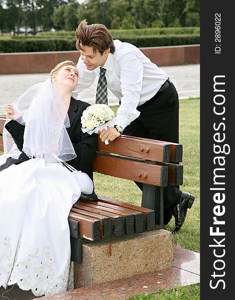 Bride sits on the bench and looks at the fiance
