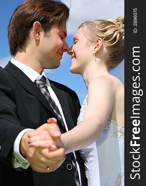 Bride looks at the fiance against the background of the sky