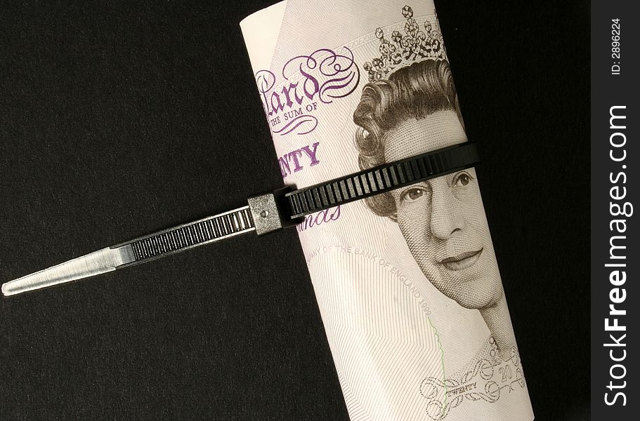 British Pound notes tied with cable strap. British Pound notes tied with cable strap.