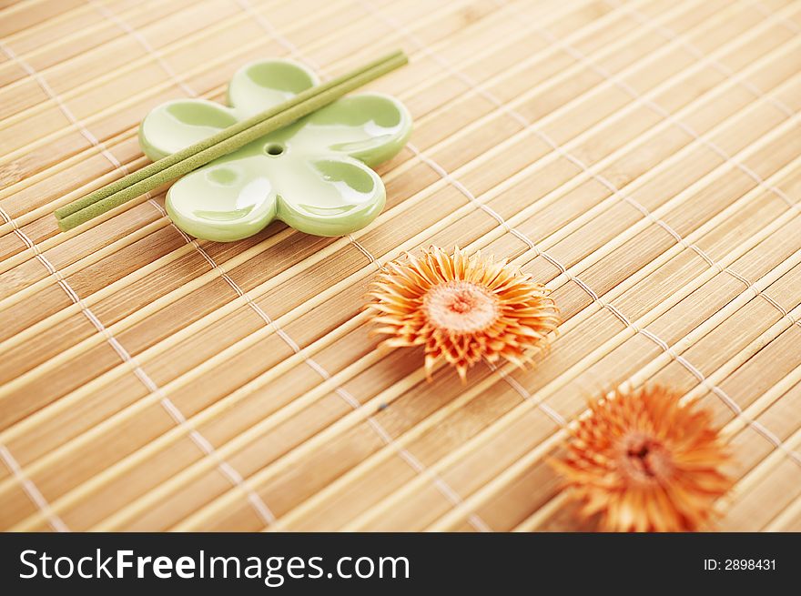 Incense stick on bamboo mat with dried flowers. Incense stick on bamboo mat with dried flowers