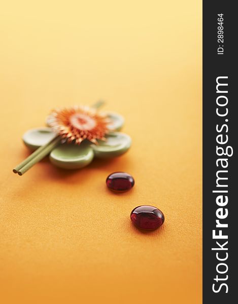 Incense sticks on the orange table with glass stones