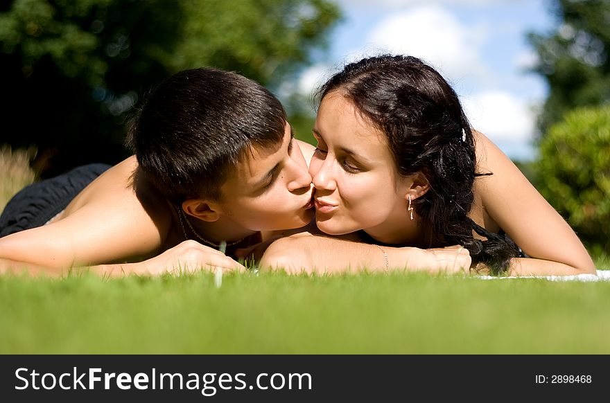 Hpappy couple lying on green grass. Hpappy couple lying on green grass.