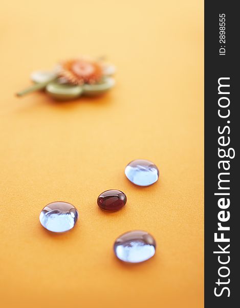 Incense sticks on the orange table with glass stones