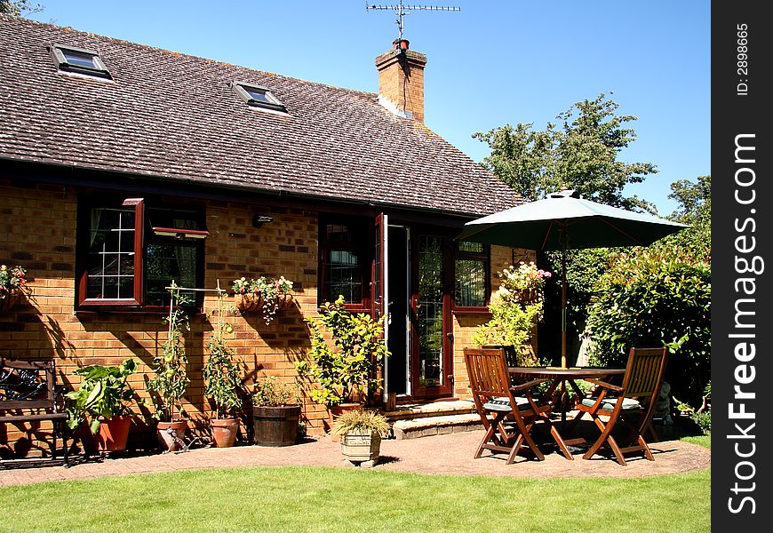 Outside Dining area with Table and Chairs and Parasol in a back garden in England. Outside Dining area with Table and Chairs and Parasol in a back garden in England