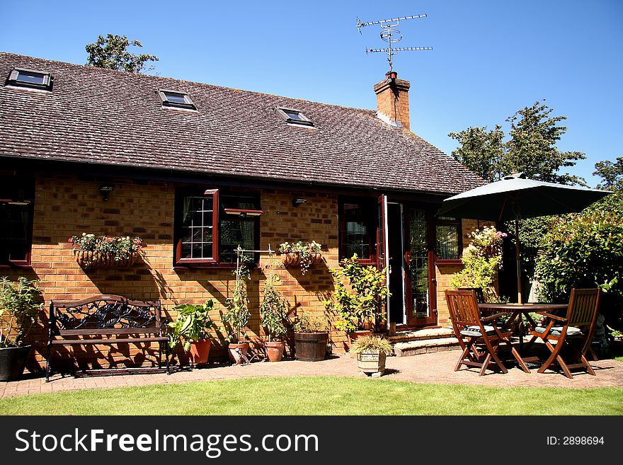 Outside Dining area with Table and Chairs and Parasol in a back garden in England. Outside Dining area with Table and Chairs and Parasol in a back garden in England