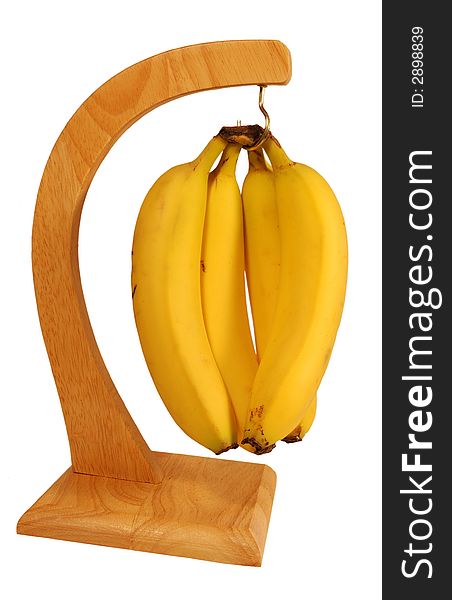 Bunch of bananas hanging from an attractive wooden stand. Bunch of bananas hanging from an attractive wooden stand.