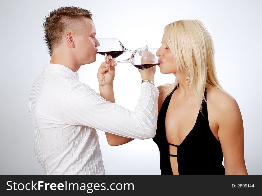 Happy young couple celebrating - drinking red wine