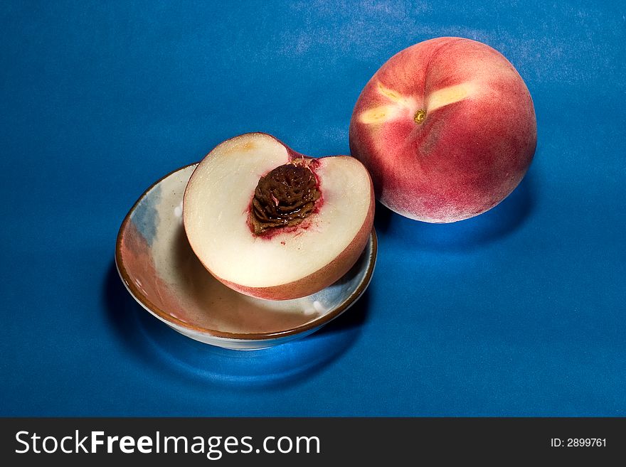 Peaches and half peach on blue background