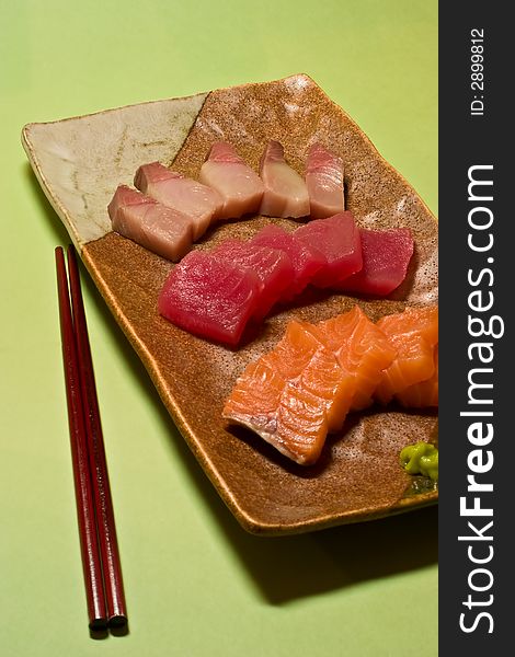 A plate of sashimi on green background