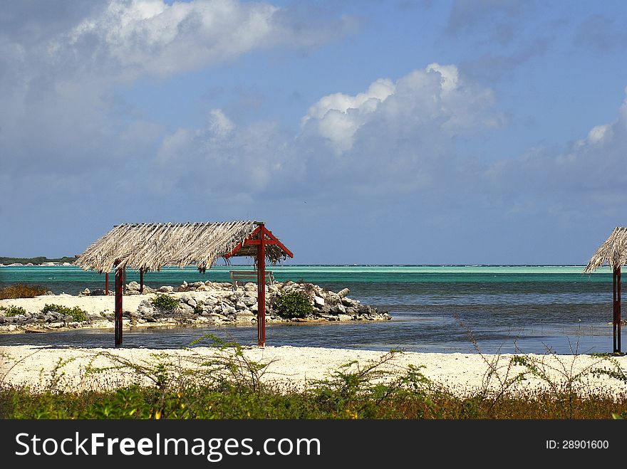 A dried frond pergola stands in a park by the sea. A dried frond pergola stands in a park by the sea