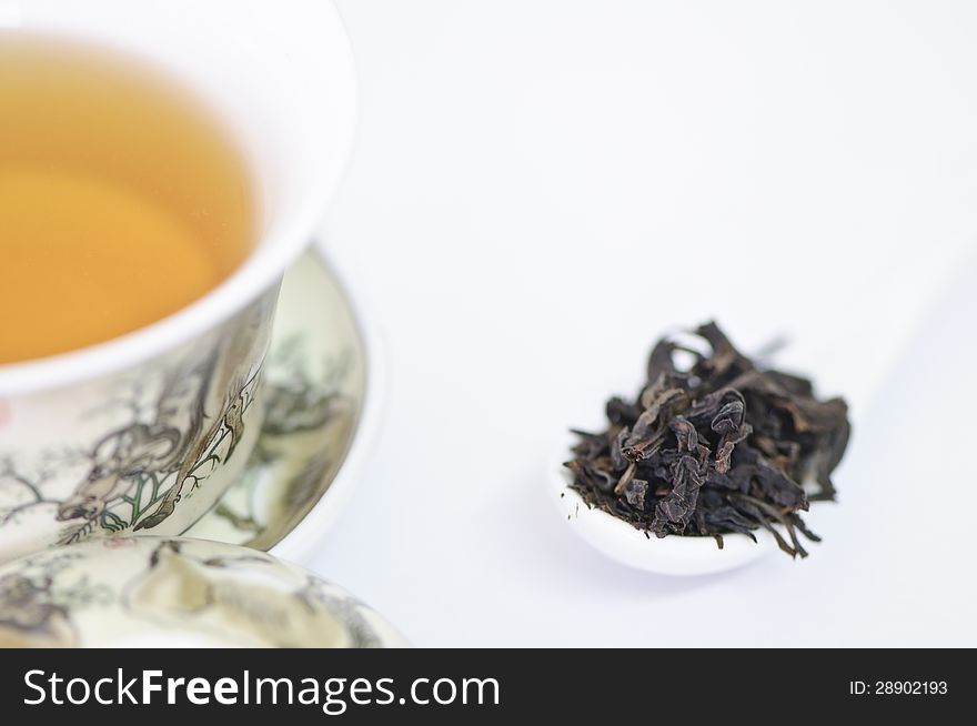 Cup Of Chinese Tea With Dry Tea Leaves  On White Background