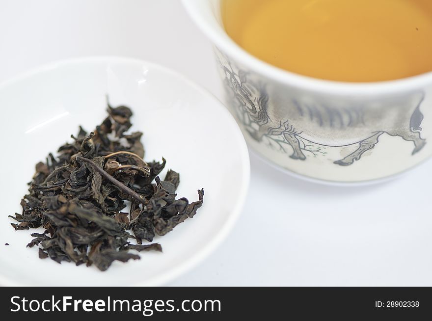 Cup Of Chinese Tea With Dry Tea Leaves Isolated On White Background