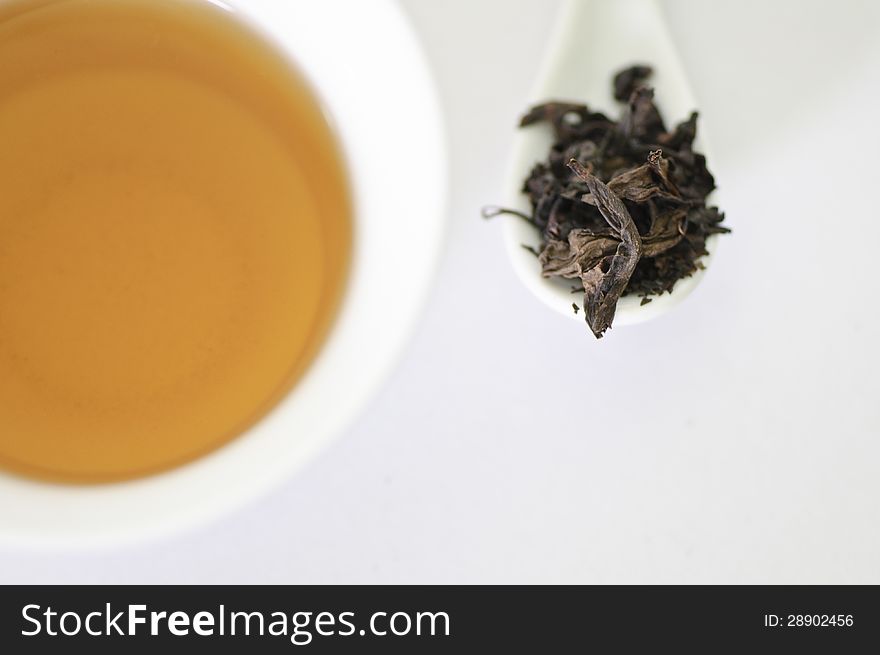 Cup Of Chinese Tea With Dry Tea Leaves Isolated On White Background