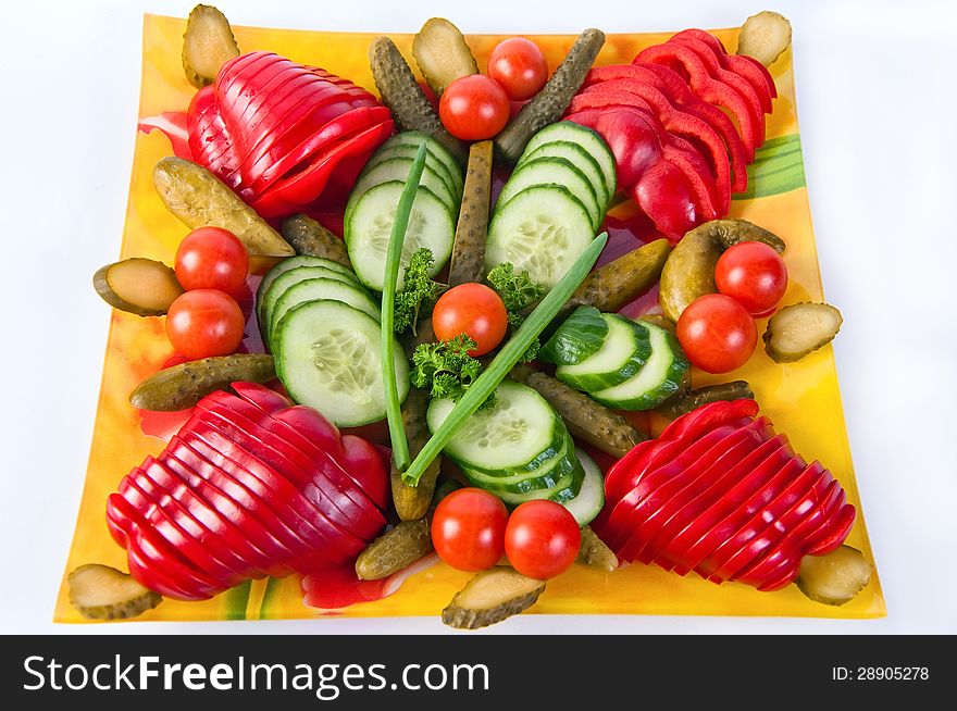 Artistically sliced vegetables on a plate isolated on white