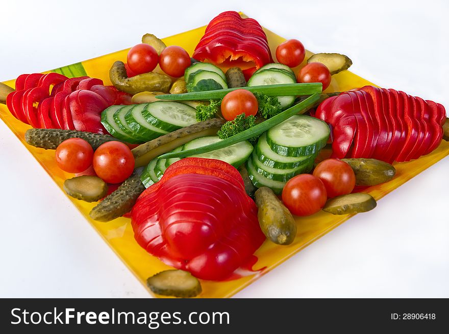 Artistically sliced vegetables on a plate isolated on white