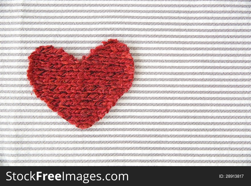 Red heart on striped fabric background