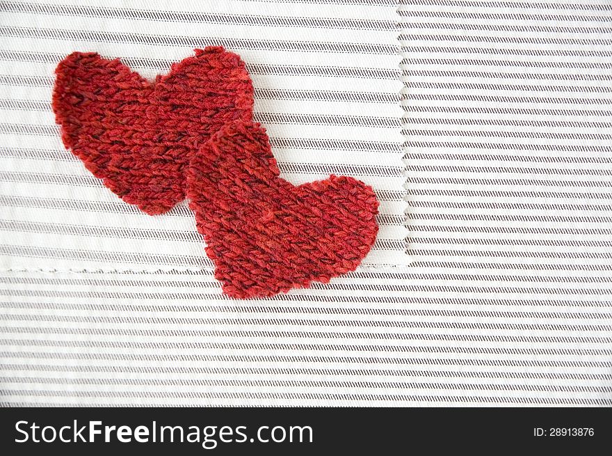 Two red hearts on striped white fabric. Two red hearts on striped white fabric