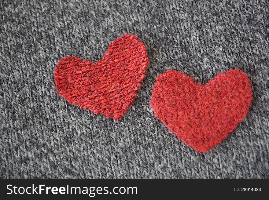 Two red hearts put together on dark fabric. Two red hearts put together on dark fabric