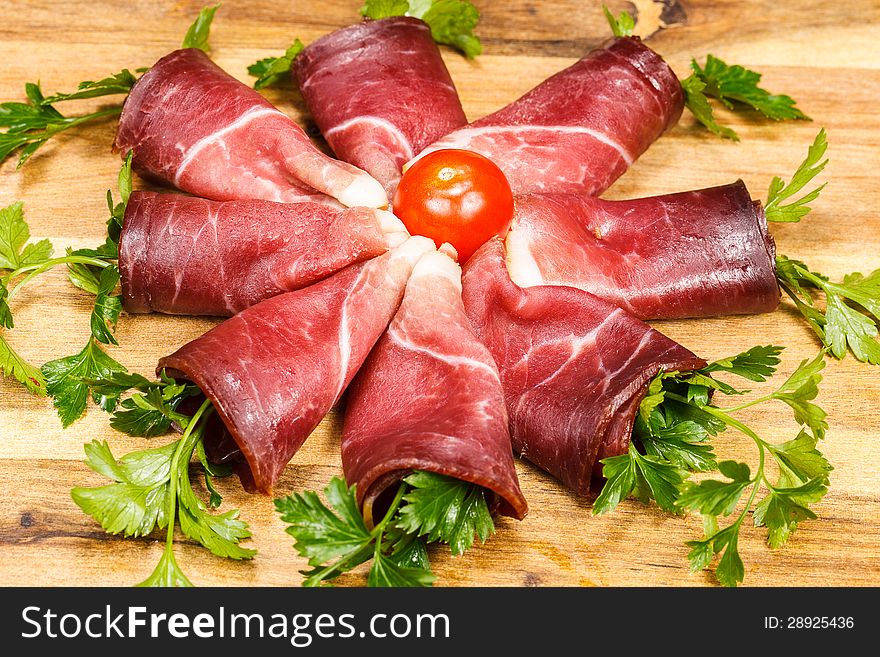 Slices of smoked prosciutto and herbs