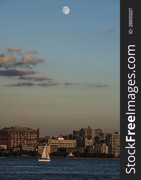 Moon over New York City and Hudson River with small Yacht