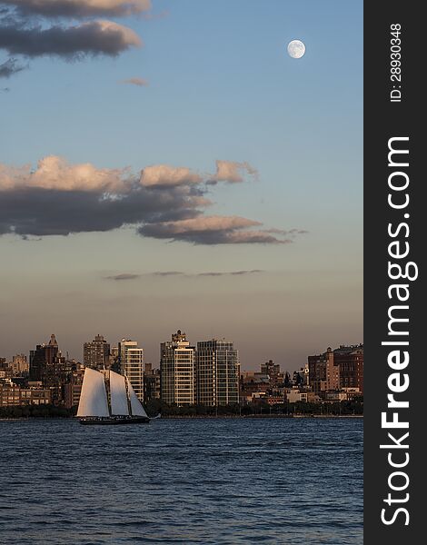 Moon over New York City and Hudson River with small Yacht