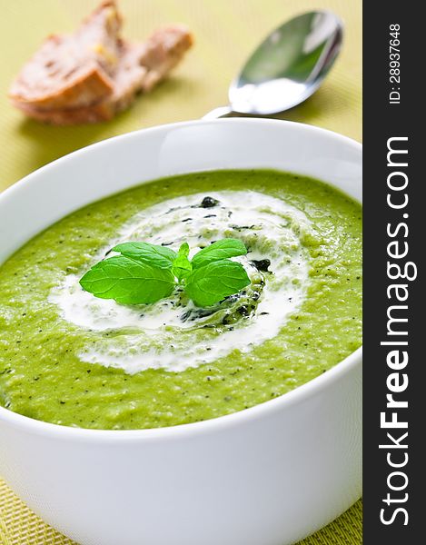 Fresh vegetable soup topped with cream and mint