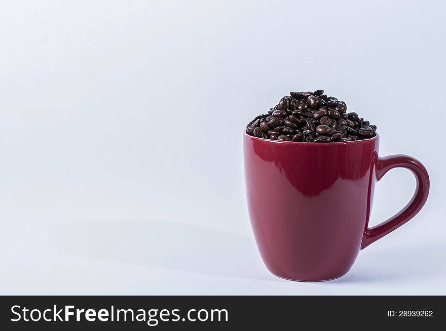 Coffe beans in a red coffee mug. Coffe beans in a red coffee mug