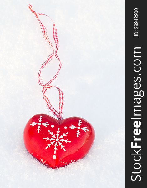 Wooden heart decoration on the snow outdoors one afternoon. Wooden heart decoration on the snow outdoors one afternoon