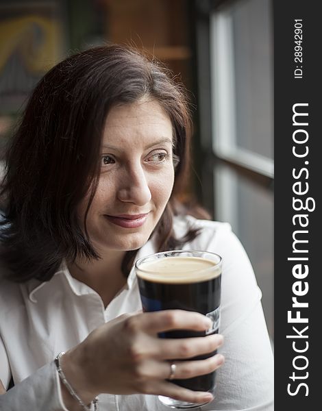 Young Woman With Beautiful Brown Eyes Drinking A Pint Of Stout