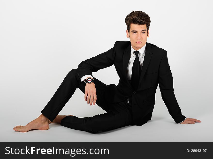Portrait of a young businessman wearing a suit, barefoot, on white background. Portrait of a young businessman wearing a suit, barefoot, on white background