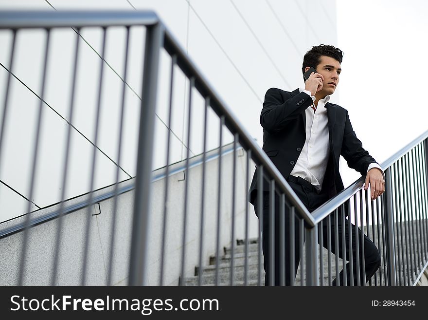 Portrait of a young businessman in an office building talking on the phone. Portrait of a young businessman in an office building talking on the phone