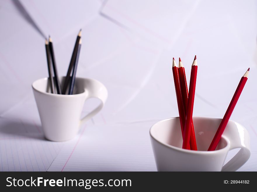 Black And Red Pencils Stand In Two Cups