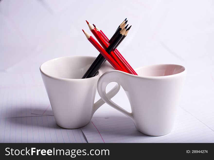 Black And Red Pencils Stand In Two Cups