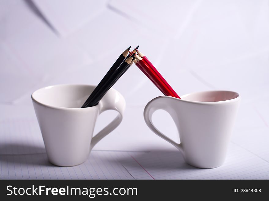 Black And Red Pencils Stand In Two Cups