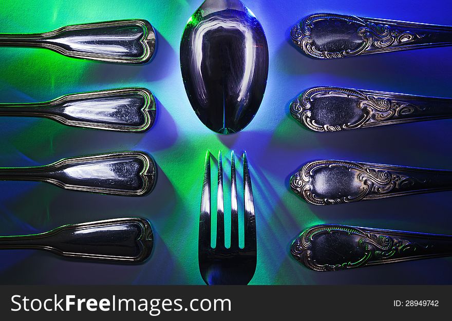 Details of forks and spoons on colorful background.