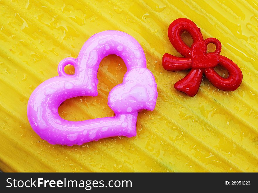 Pink and red heart on yellow banana leaf background. Pink and red heart on yellow banana leaf background